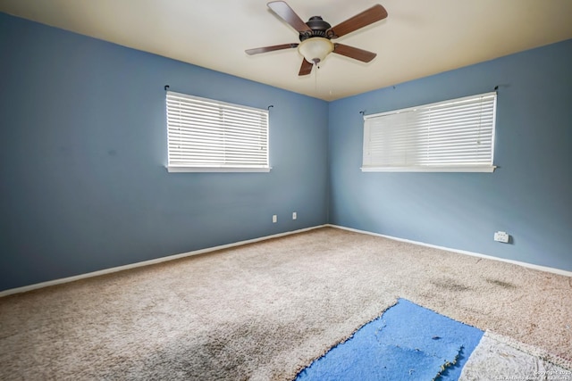 carpeted spare room featuring ceiling fan