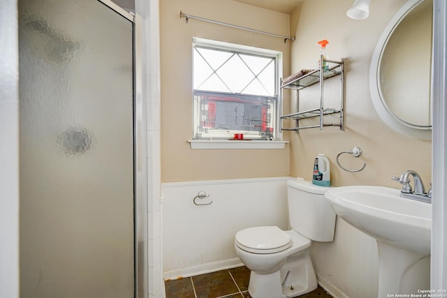 bathroom with a shower with shower door, sink, tile patterned floors, and toilet