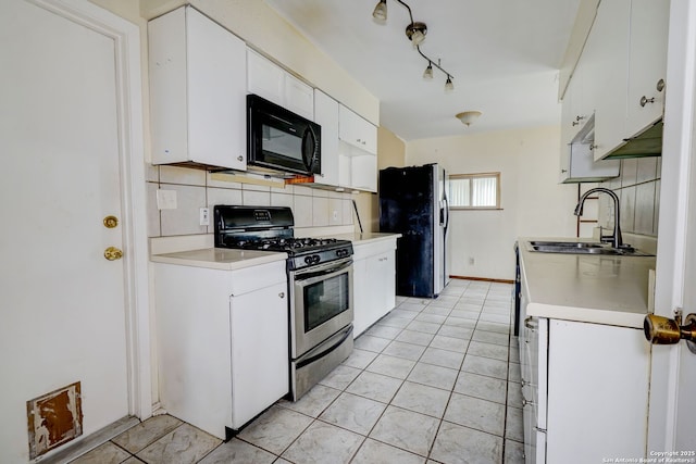 kitchen featuring refrigerator with ice dispenser, white cabinetry, stainless steel gas stove, decorative backsplash, and light tile patterned flooring