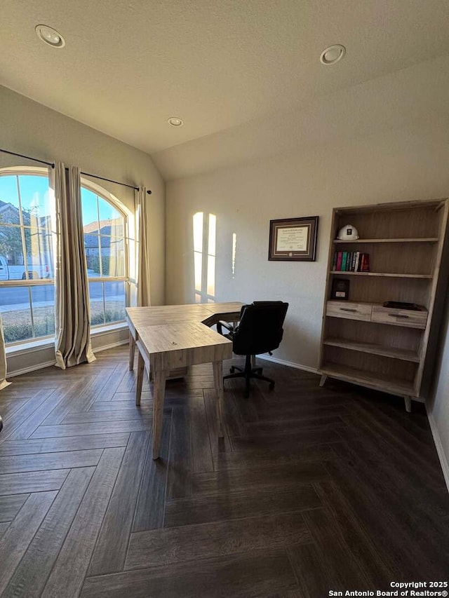 office area featuring dark parquet floors, a textured ceiling, and lofted ceiling