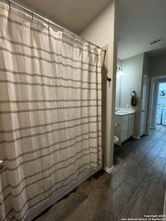 bathroom featuring vanity and independent washer and dryer