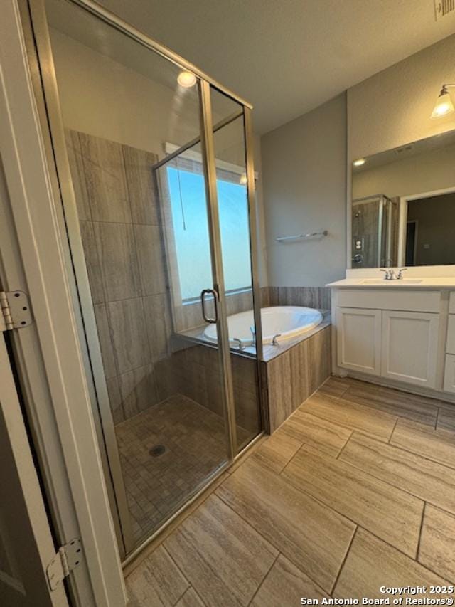 bathroom featuring vanity and shower with separate bathtub