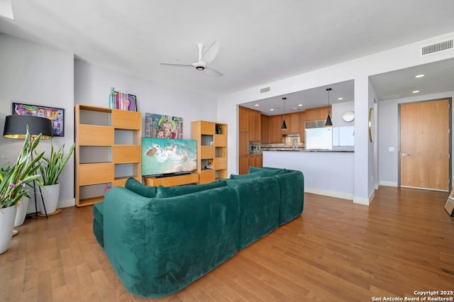 living room with ceiling fan and light hardwood / wood-style floors