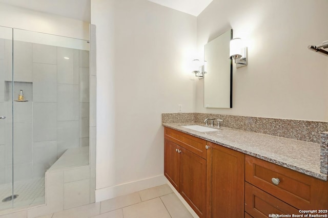 bathroom with tile patterned floors, vanity, and a tile shower