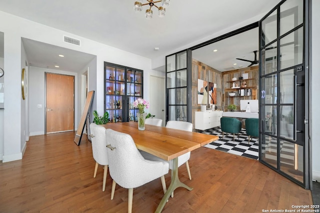 dining area with wood-type flooring and a notable chandelier