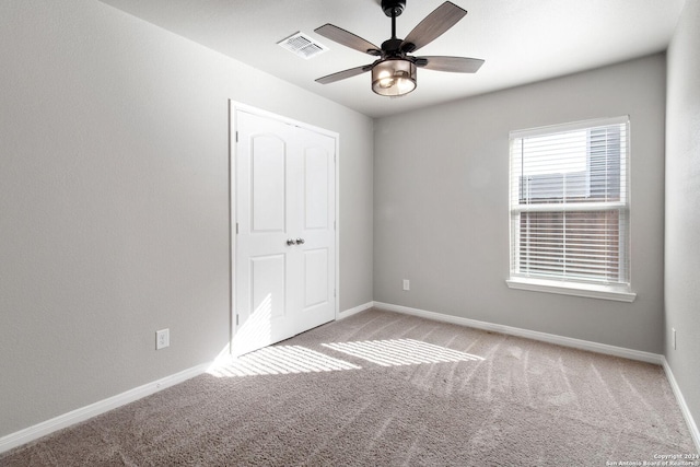 unfurnished bedroom featuring ceiling fan, light colored carpet, and a closet