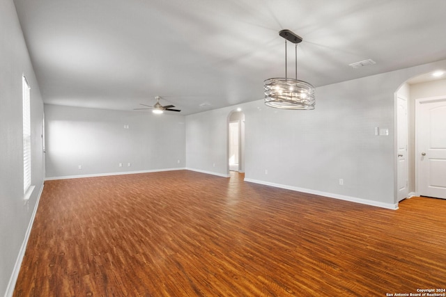 unfurnished living room featuring wood-type flooring and ceiling fan with notable chandelier