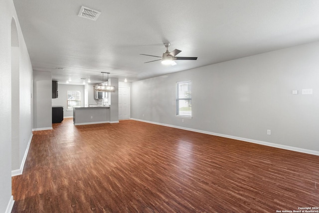 unfurnished living room featuring ceiling fan, plenty of natural light, and dark hardwood / wood-style floors