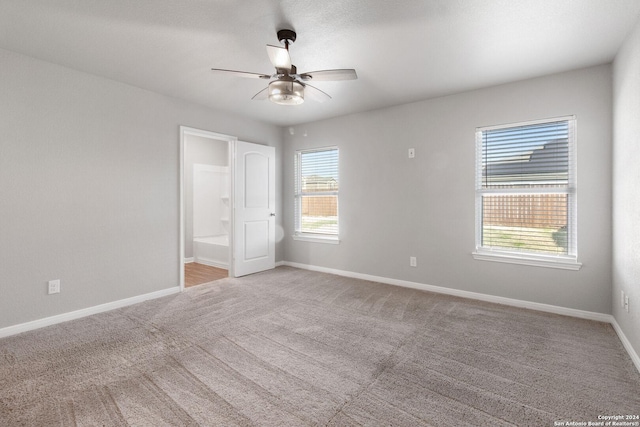 empty room with ceiling fan and light colored carpet