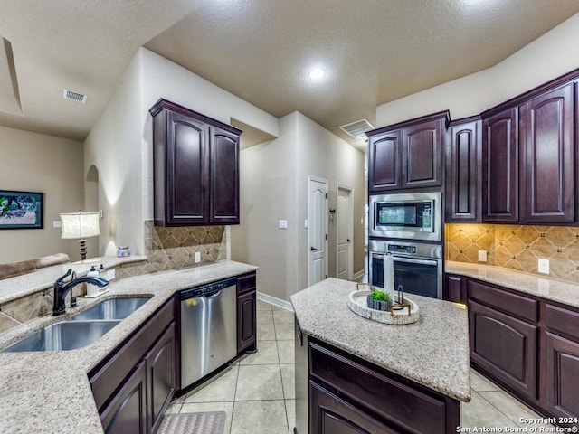 kitchen with sink, backsplash, appliances with stainless steel finishes, and light tile patterned flooring