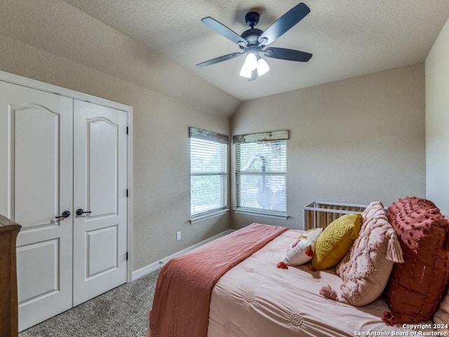 bedroom featuring ceiling fan, a closet, lofted ceiling, and carpet floors