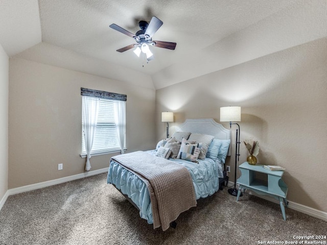 carpeted bedroom with ceiling fan, a raised ceiling, and vaulted ceiling