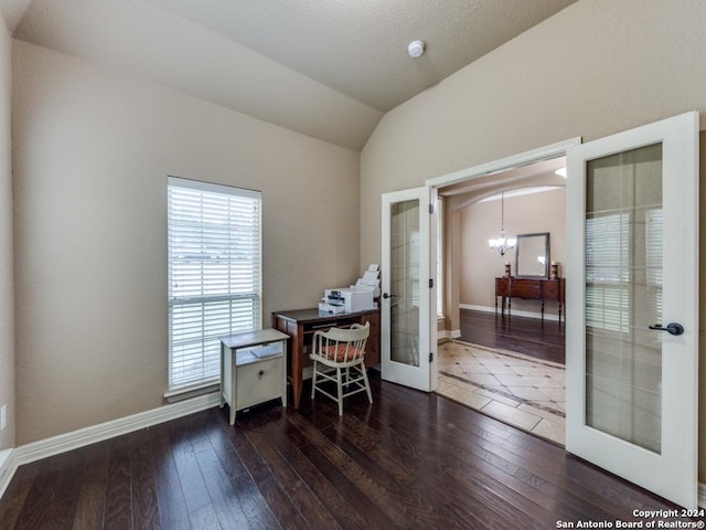 home office featuring dark hardwood / wood-style floors, lofted ceiling, french doors, and a notable chandelier