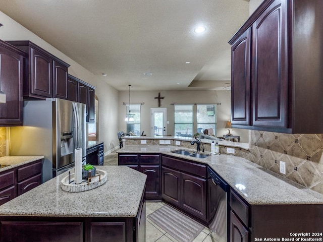 kitchen with a kitchen island, stainless steel appliances, sink, backsplash, and kitchen peninsula