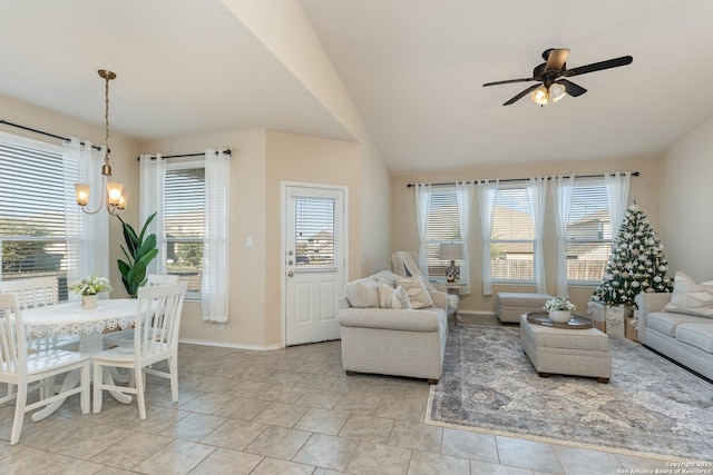 living room featuring vaulted ceiling and ceiling fan with notable chandelier