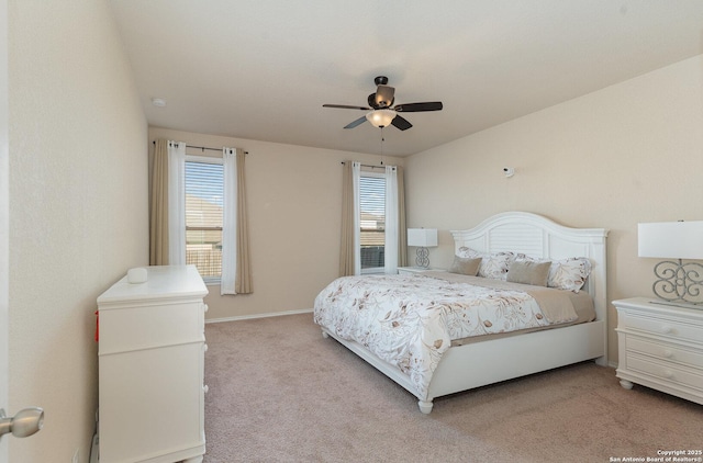 bedroom with ceiling fan, light colored carpet, and multiple windows