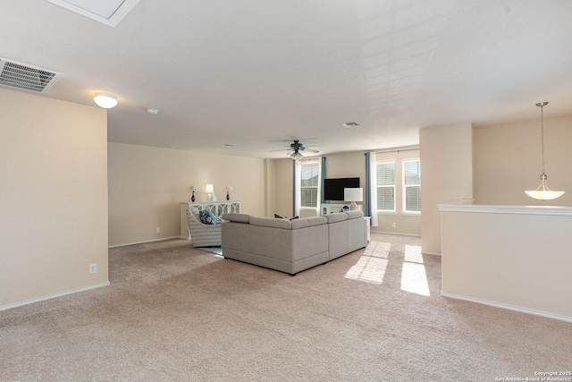 unfurnished living room featuring light carpet and ceiling fan