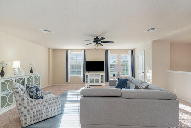 carpeted living room with ceiling fan and a textured ceiling