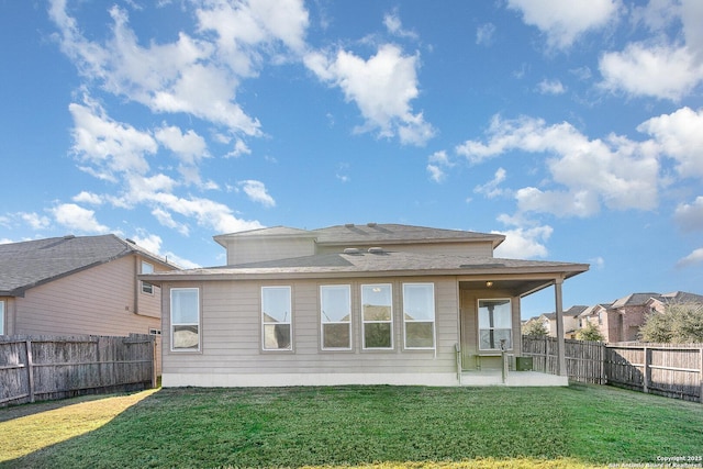 rear view of property featuring a lawn and a patio