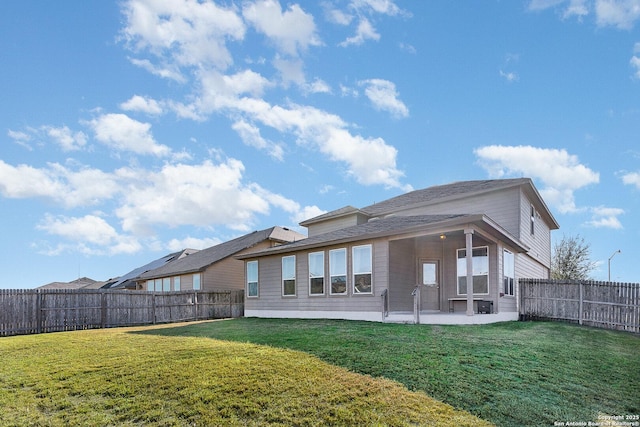 back of property with a lawn and a patio