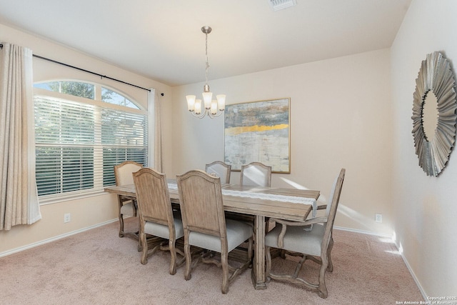 carpeted dining area featuring a notable chandelier