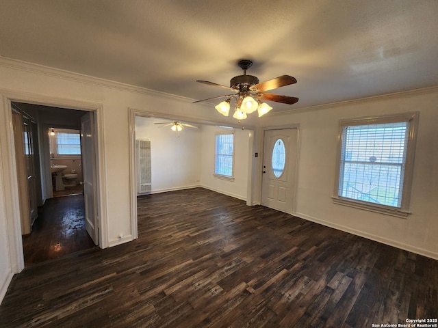 entrance foyer featuring dark wood-type flooring, crown molding, and ceiling fan