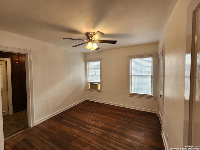 empty room featuring ceiling fan, dark wood-type flooring, and cooling unit