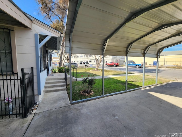 view of parking / parking lot featuring a carport and a lawn