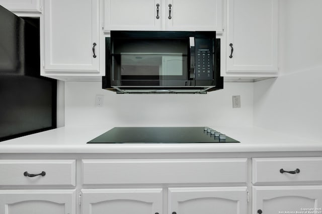 details featuring white cabinetry and black appliances