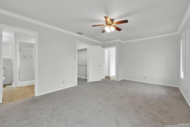 unfurnished bedroom with light carpet, ceiling fan, a closet, a walk in closet, and crown molding