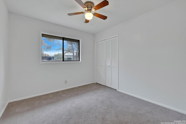 unfurnished room with ceiling fan and carpet