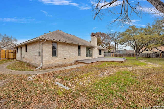 rear view of house featuring a patio area and a yard