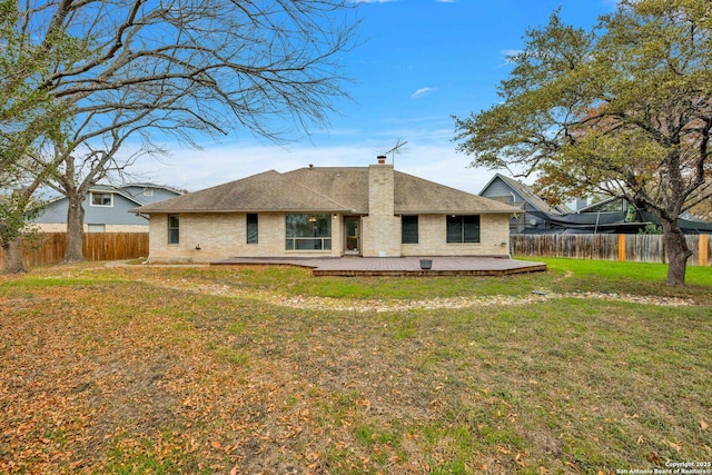 rear view of house with a deck and a yard