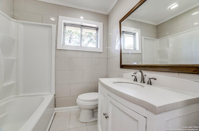 full bathroom featuring toilet, vanity, tile walls, tile patterned floors, and crown molding