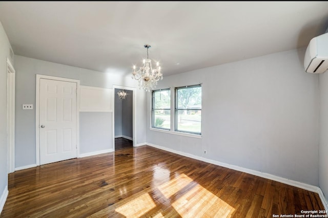 empty room with an AC wall unit, dark hardwood / wood-style flooring, and an inviting chandelier