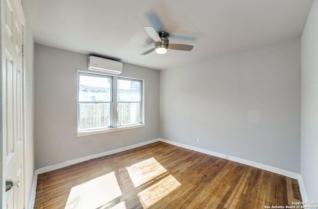 unfurnished room featuring ceiling fan, wood-type flooring, and a wall mounted air conditioner