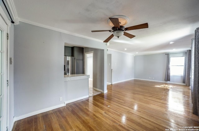 spare room with ceiling fan, light hardwood / wood-style flooring, and crown molding