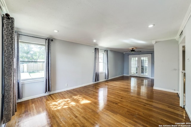 empty room featuring hardwood / wood-style flooring, ceiling fan, ornamental molding, and french doors