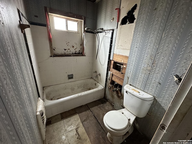 bathroom featuring toilet and a washtub