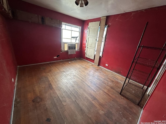 unfurnished room with cooling unit and hardwood / wood-style flooring