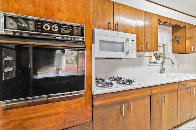 kitchen featuring backsplash, sink, white appliances, and light tile patterned flooring