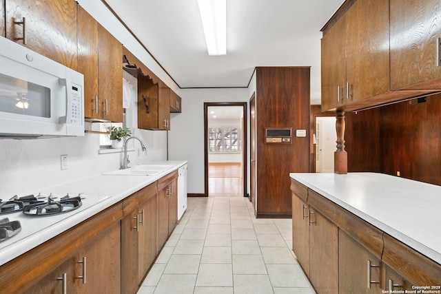 kitchen featuring sink, white appliances, and light tile patterned floors