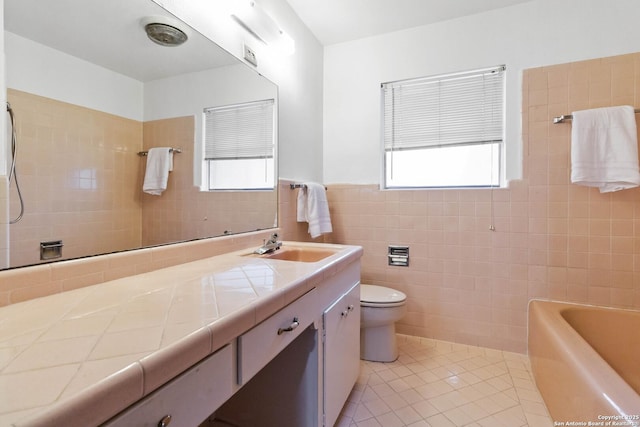 bathroom with vanity, tile walls, plenty of natural light, and tile patterned floors