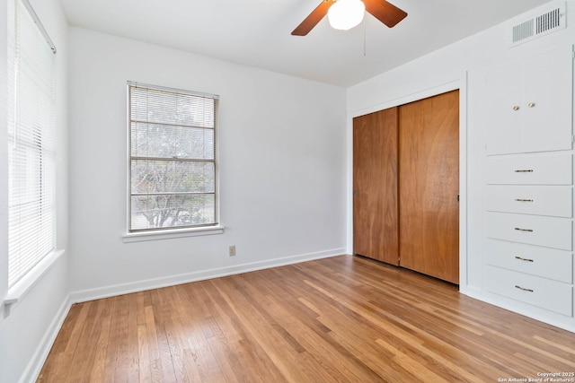 unfurnished bedroom featuring ceiling fan, a closet, and light hardwood / wood-style flooring