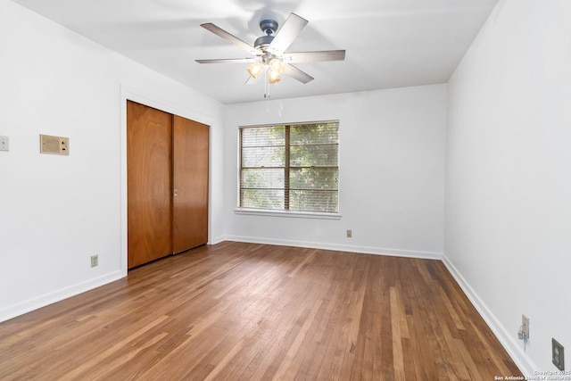 unfurnished bedroom with a closet, hardwood / wood-style floors, and ceiling fan