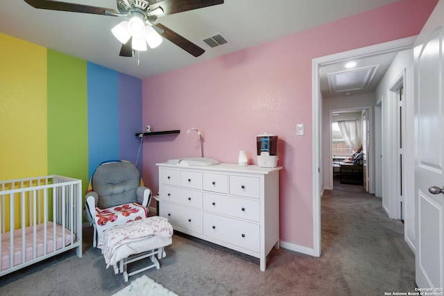 bedroom featuring ceiling fan, light colored carpet, and a nursery area