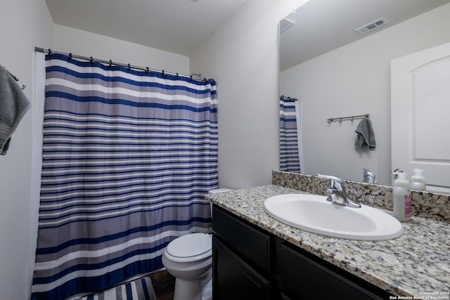 bathroom featuring wood-type flooring, toilet, and vanity