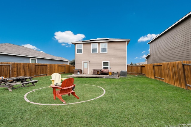 rear view of property with central AC unit, a patio area, a lawn, and solar panels