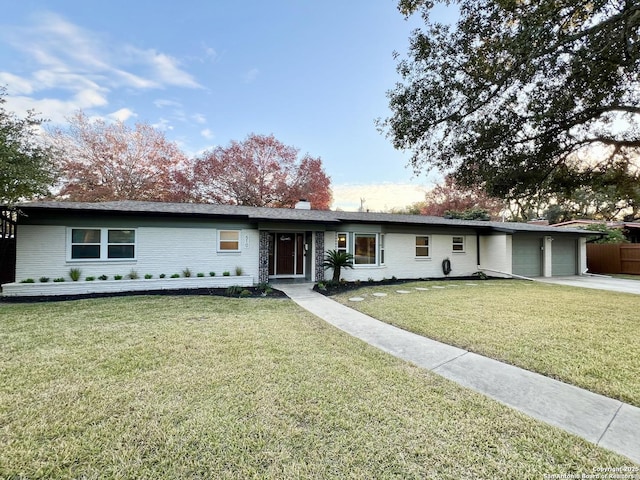 single story home featuring a front lawn and a garage