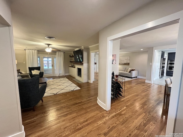 living room featuring ceiling fan and hardwood / wood-style flooring